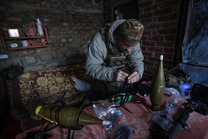 Ukraiņu karavīrs pie drona, kas pārveidots kaujas darbībai