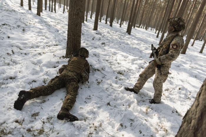 Kadet aizsegā aiz koka