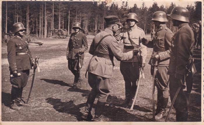 Vidzemes artilērijas pulka komandieris pulkvedis Voldemārs Skaistlauks (Šēnfelds) pasniedz karavīriem šaušanas akselbantes. 1938. gada 13. augusts.