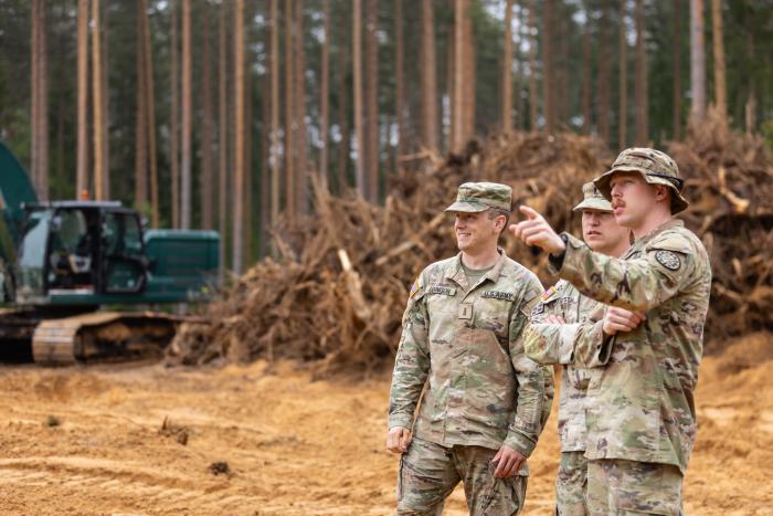 ASV karavīri pie izņemtajiem koku celmiem