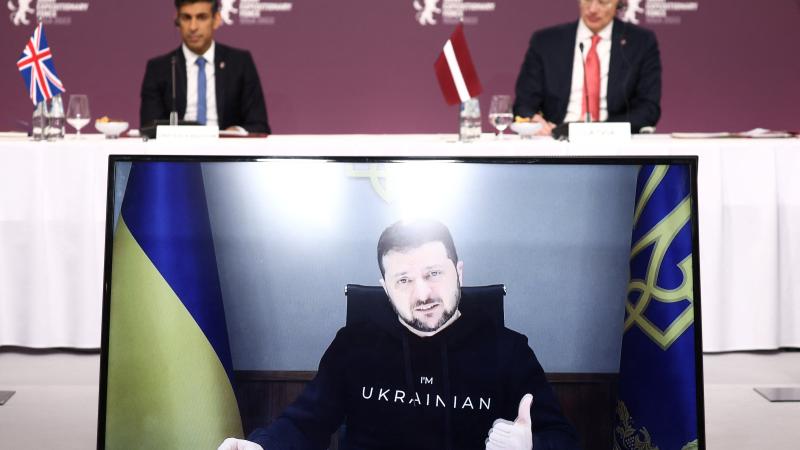 Lielbritānijas premjers Rši Sunaks un Latvijas Ministru prezidents Krišjānis Kariņš uzklausa Ukrainas prezidenta Volodimira Zelenska uzrunu Apvienoto reaģēšanas spēku dalībvalstu vadītāju tikšanās laikā Rīgā