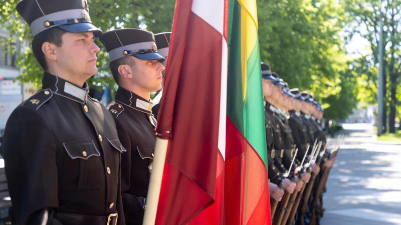 Goda sardze tur rokās Latvijas un Lietuvas karogus