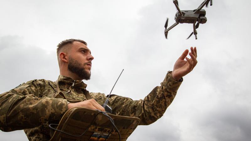 Ukrainas karavīrs ar dronu kaujas laukā